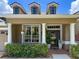 Charming front porch with white columns, decorative plants, and well-maintained landscaping at 22925 Collridge Dr, Land O Lakes, FL 34639