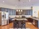 Stylish kitchen features stainless steel appliances, dark cabinetry, and an island with breakfast bar at 22925 Collridge Dr, Land O Lakes, FL 34639