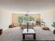 Spacious living room with a large window showcasing outdoor views and soft, neutral carpet at 22925 Collridge Dr, Land O Lakes, FL 34639