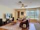 Open-concept living room with wood floors, ceiling fan, and plenty of natural light at 22925 Collridge Dr, Land O Lakes, FL 34639