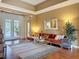 Bright living area with hardwood floors, a comfortable orange sofa, and french doors to a patio at 22925 Collridge Dr, Land O Lakes, FL 34639