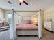 Spacious bedroom featuring a canopy bed, soft lighting and neutral tones at 22925 Collridge Dr, Land O Lakes, FL 34639