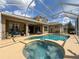 Outdoor living space with covered patio, sparkling pool, and built-in hot tub at 22925 Collridge Dr, Land O Lakes, FL 34639