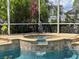 Outdoor pool and spa surrounded by lush landscaping and a screened enclosure at 22925 Collridge Dr, Land O Lakes, FL 34639