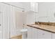 This bathroom has granite countertops, white cabinets, and tile floors at 2739 Via Capri # 1039, Clearwater, FL 33764