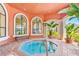 Indoor hot tub with large arched windows, seating, and greenery, ideal for relaxation at 2739 Via Capri # 1039, Clearwater, FL 33764