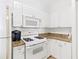 Efficient kitchen with white cabinets, granite counters, and modern appliances at 2739 Via Capri # 1039, Clearwater, FL 33764