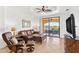 Inviting living room featuring cozy leather seating, tile floors, and a sliding glass door with a waterfront view at 2739 Via Capri # 1039, Clearwater, FL 33764