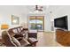 Inviting living room with leather furniture, tiled floor, ceiling fan, and water views from the sliding glass door at 2739 Via Capri # 1039, Clearwater, FL 33764