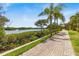 Paver walkway next to a water view featuring palm trees and lush greenery at 2739 Via Capri # 1039, Clearwater, FL 33764