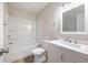 A neutral bathroom featuring a modern vanity, a soaking tub with shower, and stylish hardware at 314 Circle Dr, Palm Harbor, FL 34683