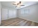 A bedroom with wood-look floors, ceiling fan, a standard closet, and a window for natural light at 314 Circle Dr, Palm Harbor, FL 34683