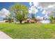 A lovely home is complemented by a mature shade tree, a green front lawn, and neutral paint at 314 Circle Dr, Palm Harbor, FL 34683