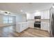 Bright kitchen features white cabinets, stainless steel appliances, quartz countertops, and hardwood floors at 314 Circle Dr, Palm Harbor, FL 34683