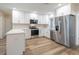 Bright kitchen features white cabinets, stainless steel appliances, quartz countertops, and hardwood floors at 314 Circle Dr, Palm Harbor, FL 34683