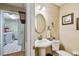 Bright bathroom with a pedestal sink, framed mirror, and a view into the laundry room at 3304 W Harbor View Ave, Tampa, FL 33611