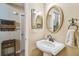 Charming bathroom featuring a pedestal sink, decorative mirror, and stylish towel rack at 3304 W Harbor View Ave, Tampa, FL 33611