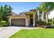 Charming home features a well-maintained lawn, landscaping, and a two-car garage at 3304 W Harbor View Ave, Tampa, FL 33611