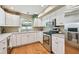 Well-lit kitchen featuring stainless steel appliances and white cabinetry at 3304 W Harbor View Ave, Tampa, FL 33611