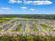 Aerial view of a residential community with a central lake surrounded by houses and greenery at 33657 Field Maple Loop, Wesley Chapel, FL 33545