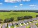 Neighborhood homes overlook a vast green field under a blue sky filled with fluffy white clouds at 33657 Field Maple Loop, Wesley Chapel, FL 33545