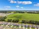 Aerial view of a neighborhood with single-Gathering homes, manicured lawns, and large green spaces at 33657 Field Maple Loop, Wesley Chapel, FL 33545