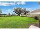 Expansive backyard with lush green grass and trees, featuring an A/C unit and fenced perimeter at 33657 Field Maple Loop, Wesley Chapel, FL 33545