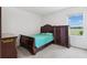 Cozy bedroom featuring a dark wood bed frame, matching dresser, and a bright window with a view at 33657 Field Maple Loop, Wesley Chapel, FL 33545