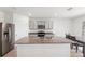 Bright kitchen features a large island with granite countertops, stainless steel appliances, gray cabinets, and tile flooring at 33657 Field Maple Loop, Wesley Chapel, FL 33545