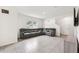 Spacious living room with gray tile flooring, a large sectional sofa, and large windows at 33657 Field Maple Loop, Wesley Chapel, FL 33545