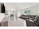 Open-concept living room with tile flooring, a large sectional sofa, and sliding glass doors to the backyard at 33657 Field Maple Loop, Wesley Chapel, FL 33545