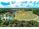 Aerial view of community baseball fields and recreation area with a pool and pond at 3682 Johnstown St, North Port, FL 34288