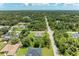 An aerial perspective shows a home in a green, leafy area with a well-maintained street at 3682 Johnstown St, North Port, FL 34288