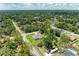Aerial view showcases home with green lawn and mature trees in a quiet residential neighborhood at 3682 Johnstown St, North Port, FL 34288