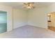 Bedroom features soft carpeting, a ceiling fan, and an open entry to a bathroom at 3682 Johnstown St, North Port, FL 34288