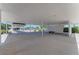 A covered parking area with white pillars and a concrete floor, and vegetation in the background at 3682 Johnstown St, North Port, FL 34288