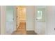 Hallway displaying wood-look floors and views into the bath and bedroom at 3682 Johnstown St, North Port, FL 34288
