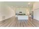 An open-concept kitchen featuring modern white cabinetry, an island with counter seating, and stainless steel appliances at 3682 Johnstown St, North Port, FL 34288