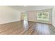 Empty living room featuring modern floors and natural light from a window and sliding glass door at 3682 Johnstown St, North Port, FL 34288