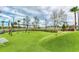 Community playground featuring swings and a climbing hill with artificial turf at 3682 Johnstown St, North Port, FL 34288