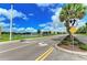 Scenic street view with a water feature, palm trees, and well-maintained landscaping at 3682 Johnstown St, North Port, FL 34288