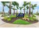 Entrance to Wellen Park featuring lush landscaping, a decorative sign, and palm trees at 3682 Johnstown St, North Port, FL 34288