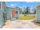 Backyard featuring a detached garage, light-green house, steps, and a large patio at 3940 Miramar S Way, St Petersburg, FL 33705