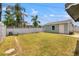 Backyard featuring green grass, white fence, light-green siding garage, and patio at 3940 Miramar S Way, St Petersburg, FL 33705