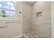 Bathroom shower with decorative tile accents, seat, showerhead, and window at 3940 Miramar S Way, St Petersburg, FL 33705