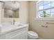 Bathroom featuring marble countertop, sleek faucet, tiled shower, and window with natural light at 3940 Miramar S Way, St Petersburg, FL 33705