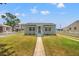 Charming light blue home with awnings and a well-manicured lawn at 3940 Miramar S Way, St Petersburg, FL 33705