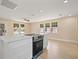 Bright open concept kitchen with white cabinetry, granite countertops and new stove at 3940 Miramar S Way, St Petersburg, FL 33705