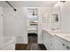 Bright bathroom featuring dual sinks, a bathtub, and a doorway leading to the bedroom at 4008 Pine Limb Ct, Tampa, FL 33614