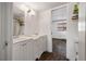 This is a shared bathroom with dual sinks, wood look tile and updated fixtures at 4008 Pine Limb Ct, Tampa, FL 33614